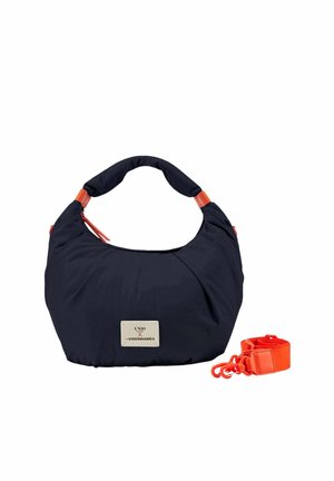 Sac à main noir en forme de croissant avec des accents orange et une bandoulière orange amovible, comportant une étiquette avant avec un logo textuel.