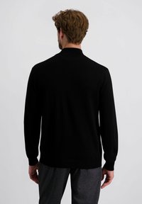 Schwarzer Strickpullover mit langen Ärmeln und einem gerippten Kragen, der eine glatte Textur und einen taillierten Schnitt aufweist, von hinten betrachtet.