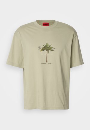 Světle zelené bavlněné tričko s grafikou palmy a textem. Kulatý výstřih, krátké rukávy, volný střih, červená značka na límci.