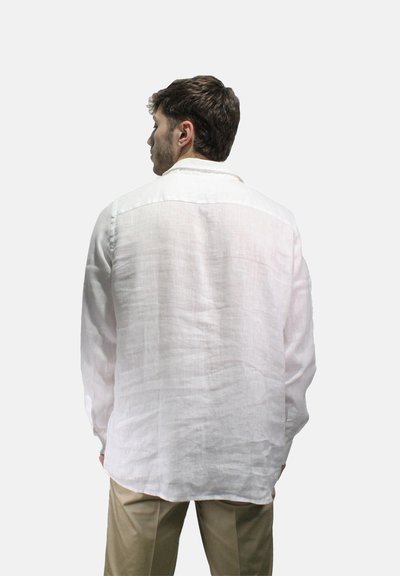 Camicia bianca di lino con vestibilità rilassata, maniche lunghe e colletto. Il tessuto presenta una leggera consistenza ed è leggero e traspirante.