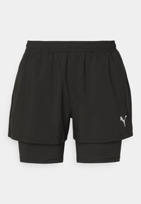 Pantalones cortos deportivos negros hechos de tela liviana, con una cinturilla elástica, forro de compresión interior y detalle de logo plateado.