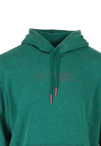 Felpa verde con cappuccio regolabile, caratterizzata da punte rosa in contrasto e logo ricamato "Squid Game" ed emblematico Puma sul petto.