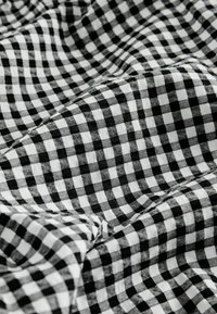 Fekete-fehér kockás anyag, puha textúrával, klasszikus gingham mintával, egyenlő méretű négyzetekkel.