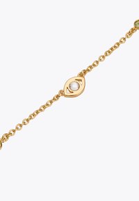 Bracelet en chaîne dorée avec un charme en forme d'œil, doté d'une pierre précieuse centrale claire et d'un délicat travail de découpes.