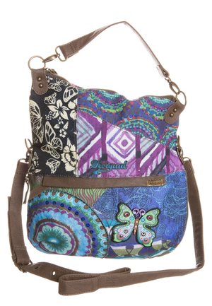 Kleurrijke schoudertas in patchworkstijl met bloemen-, vlinder- en geometrische patronen, bruine banden en het merklabel "Desigual" op de stof.