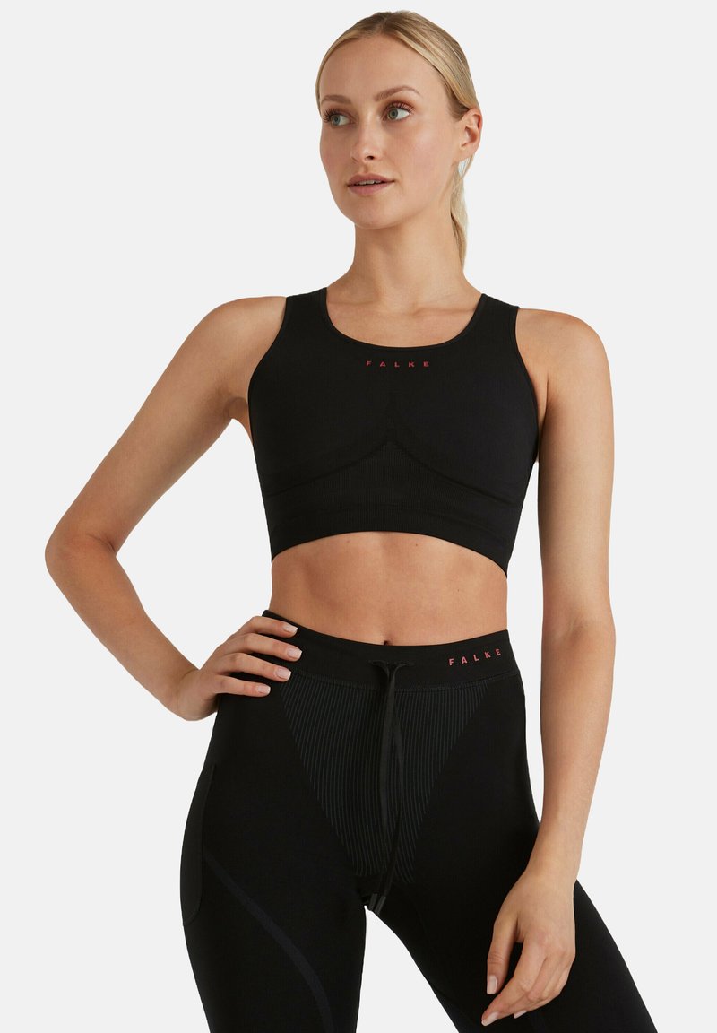 Czarny sportowy top typu crop z dopasowanym krojem, teksturowaną tkaniną i bezszwowym wyglądem. Na klatce piersiowej znajduje się czerwone logo.