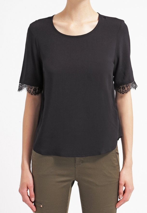 Svart kortärmad topp med rundad halsringning och spetsdetaljer på ärmarna. Slät tyg med en avslappnad passform och något rundad nederkant.