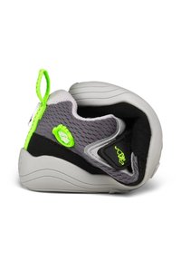 Scarpa da ginnastica piegata grigia e nera con linguetta e dettagli verde neon, suola flessibile e tomaia in mesh traspirante.