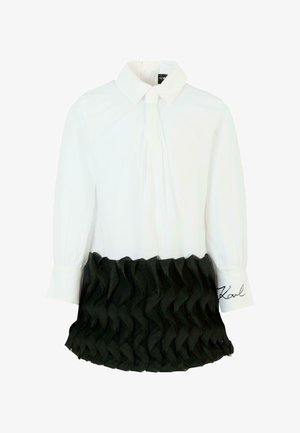 Camicia bianca a maniche lunghe con colletto appuntito, dettaglio arricciato nero testurizzato in vita e ricamo distintivo sul polsino.