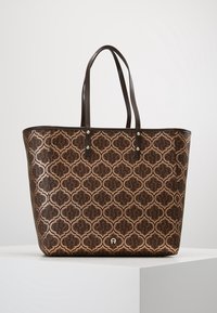 Torba typu tote z brązowym, wzorzystym zewnętrzem o geometrycznym wzorze, ciemnobrązowymi uchwytami i metalicznymi akcentami. Wykonana z teksturowanego syntetycznego materiału.