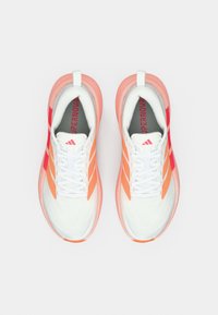 Λευκά αθλητικά παπούτσια με πορτοκαλί και ροζ διαβαθμισμένες λεπτομέρειες, με υφασμένο επάνω μέρος, δέσιμο με κορδόνια και λογότυπο "SUPERNOVA" στη γλώσσα.