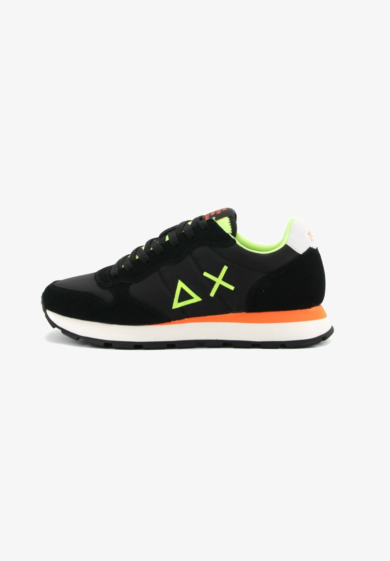 Scarpa sportiva nera realizzata in materiali scamosciati e mesh. Presenta dettagli verdi, una suola arancione e un logo geometrico sul lato.