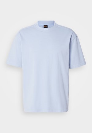 T-shirt de ganga azul claro, de manga curta e decote redondo, com uma pequena etiqueta da marca BOSS em preto e laranja na gola.