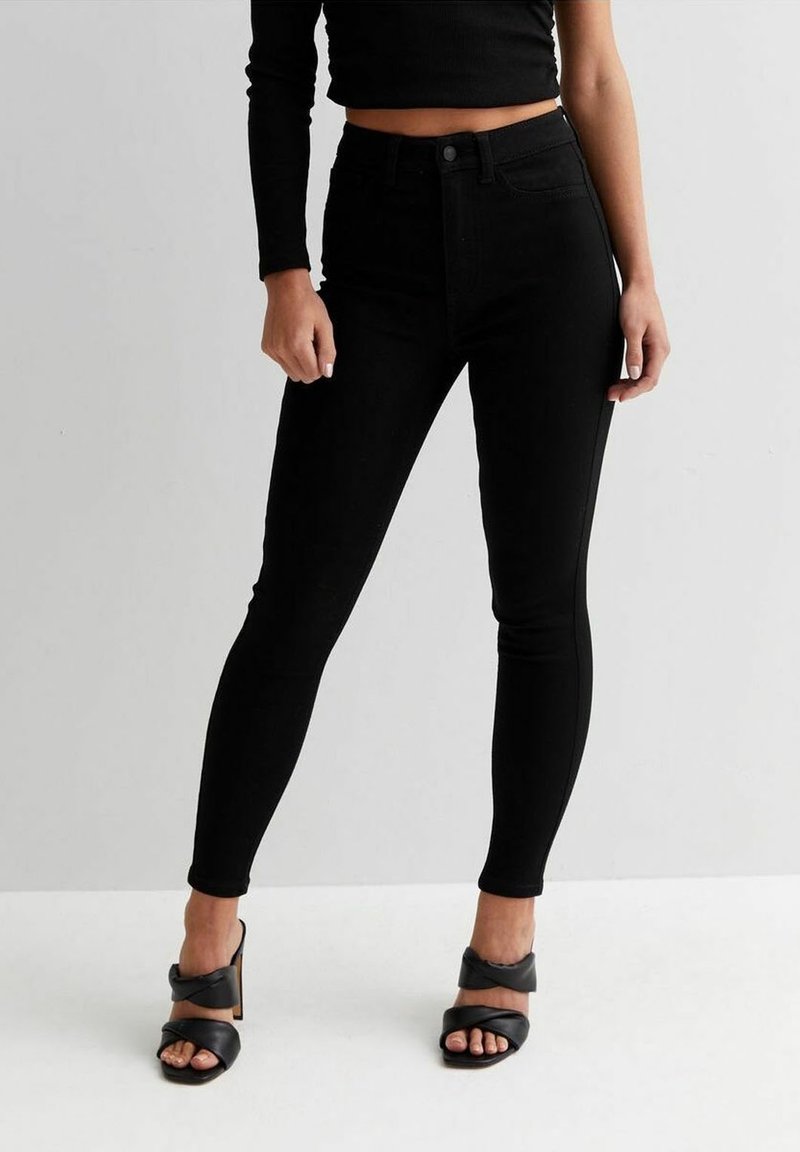 Jeans skinny neri a vita alta realizzati in denim, con un design aderente, stile classico a cinque tasche e dettagli di cucitura minimi.