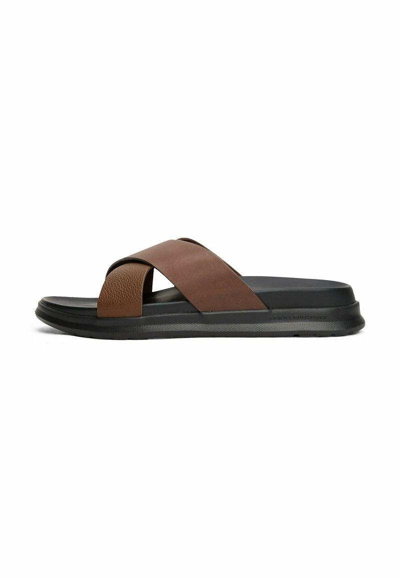 Sandale à enfiler pour homme avec des brides croisées en cuir marron et une semelle noire rembourrée, vue latérale sur fond blanc.