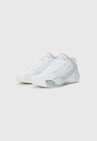 White athletic shoes with mesh and synthetic materials, featuring a rounded toe, flat laces, and a grey accent on the sole.
