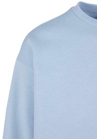 Gaiši zils džemperis ar apaļu kakla izgriezumu, izgatavots no mīksta auduma. Izturīgs un gluds tekstūras dizains ar brīvi pieguļošām piedurknēm.