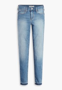 Jeans de denim azul claro con un diseño ajustado, cinco bolsillos y dobladillos deshilachados. La tela es suave, con un lavado desgastado y detalles de costura casual.