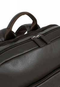 Borsa in pelle marrone con superficie liscia, doppi zip e manico imbottito. La cucitura discreta aggiunge dettagli al design strutturato.