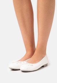 Białe baletki z gładkiej skóry, z zaokrąglonym czubkiem, z małym akcentem w postaci kokardki na wierzchu i niskim obcasem.