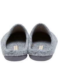 Grå følesko med en rund, åben bagside, blød tekstur og sål i fladt gummi. Indvendigt ses en lys tan-foring.