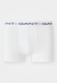 Boxer blanc pour homme avec une ceinture logo bleu marine portant l'inscription "GANT", présenté sur un fond blanc uni.