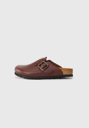 Brown leather clog with a textured finish, adjustable buckle, and cork accent on the back. Rubber sole for grip and durability.
