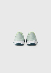Baskets de sport vert clair avec une tige en mesh texturé, semelle blanche et accents bleu sarcelle foncé. Comprend un col de talon rembourré pour le confort.