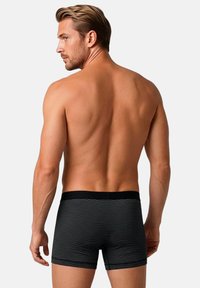 Black striped boxer shorts with a soft elastic waistband, fitted design, and smooth texture, viewed from the back on a neutral background.