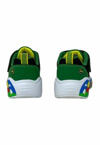 Grønne og sorte sneakers med Velcro-stropper og hvide såler; har farverige grafikker med gård-tema på hælene. Gule detaljer på tungen.
