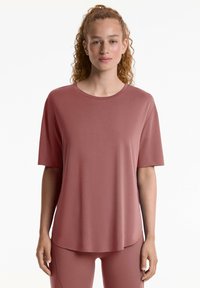 T-shirt a maniche corte, dalla vestibilità ampia, in un colore rosa polveroso. Realizzato in un tessuto morbido e leggero, con scollatura rotonda e orlo leggermente curvato.
