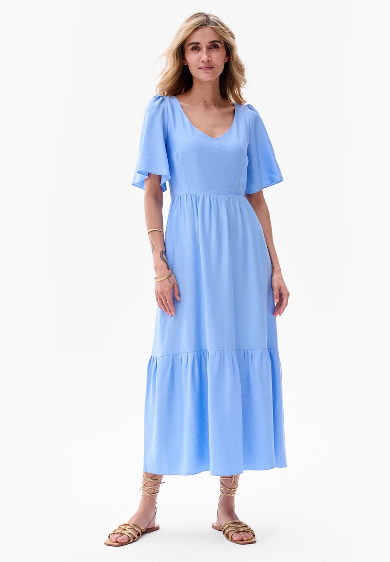Jasnoniebieska sukienka maxi z krótkimi falbaniastymi rękawami, dekoltem w serek, dopasowanym toplinem oraz warstwowym, falbaniastym dołem. Gładka, lekka tekstura materiału.