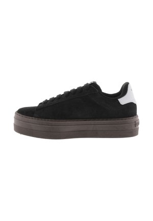 Sneaker in suede nero con suola in gomma marrone spessa, punta arrotondata e design con lacci. Presenta un accento del tallone bianco a contrasto.