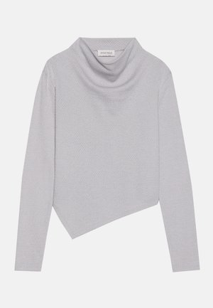 Lys grå genser med høy hals og lange ermer, asymmetrisk kant, teksturert strikket stoff, og merket "ANNA FIELD" synlig innvendig i halsen.