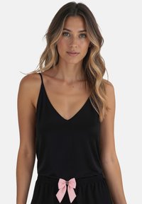 Top negro sin mangas con escote en V, hecho de una tela suave. Presenta un lazo rosa en la cintura. Diseño simple y elegante.