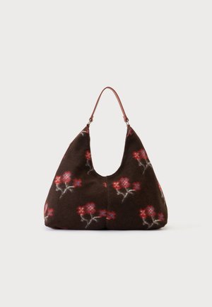 Blød brun håndtaske med røde og blå blomsterprint, en rundet trekantet form og en enkelt tynd brun skulderrem.