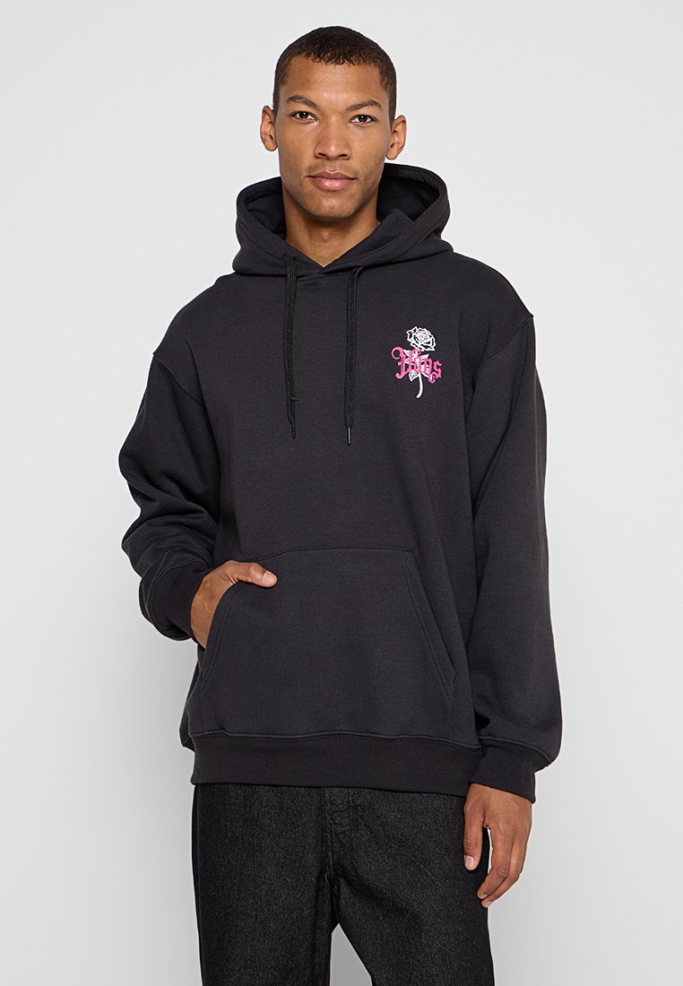 Czarna bluza z kapturem z przednią kieszenią, sznurkami i różowym wzorem graficznym przedstawiającym różę oraz tekst. Standardowy krój z ściągaczami przy mankietach.