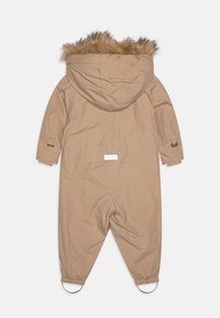 Beige isolierter Overall mit einer Kapuze aus Kunstfell, elastischen Bündchen und einem Etikett im unteren Rückenbereich. Glatte Textur und aerodynamisches Design.