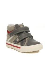 Grijze en beige hoge sneakers met dubbele klittenbandsluitingen, witte stiksels, rode accenten en een getextureerde rubberen zool.