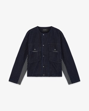 Chaqueta de mezclilla oscura con dos bolsillos frontales, botones a presión y paneles laterales a cuadros. Cuello redondo y mangas largas, diseño casual.