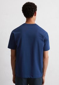 Heren navyblauwe katoenen t-shirt met korte mouwen en een ronde hals. Gladde textuur, normale pasvorm, geen zichtbare patronen of accenten.