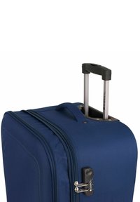 Maleta rodante de tela color azul marino con cremalleras dobles, hardware de metal y mango extensible. Textura suave y forma estructurada.