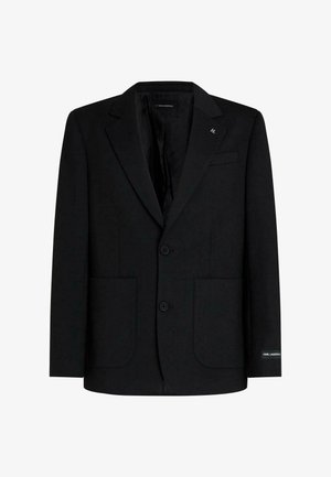 Zwarte gestructureerde blazer met inkepingrevers, twee opgestikte voorzakken, twee knopen en subtiele branding op mouw en borst.