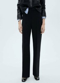 Black tailored trousers, high-waisted with pleats, made of smooth material; paired with a fitted black jacket and shiny shoes.