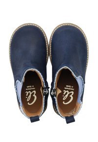 Botines de cuero azul marino con detalles en azul claro, costuras color canela y cremalleras laterales. El interior presenta una plantilla marrón con la marca.