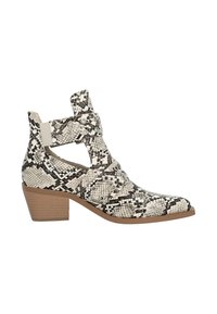 Botín de tobillo de piel de serpiente en blanco y negro, con laterales recortados, cintas anchas con tachuelas metálicas y un bajo tacón cuadrado.