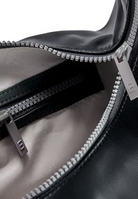 Čierna kožená taška s šedým zipsom. Interiér je vybavený hladkým, svetlým textilom a ďalšou zipsovou priehradkou na zadnej strane.