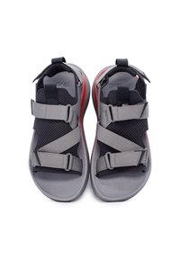 Sandali sportivi grigi con tomaia in rete nera e cinghie grigie, dotati di chiusure regolabili in Velcro e un dettaglio rosso sulla suola.