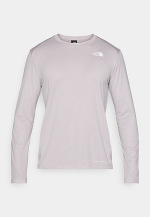 Ljuslila långärmad skjorta gjord av textil och ventilerande tyg. Har en rund halsringning och en liten logotyp på övre vänster bröst.