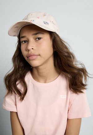 Baseball cap features a light pink fabric with a colorful pattern of small rainbows and hearts. The front includes a small logo patch.